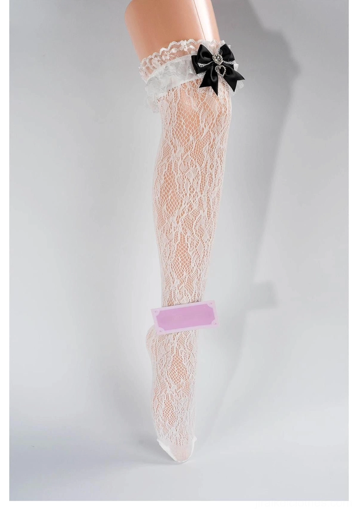 Cream lace mid-calf Jirai Kei socks with white ruffled cuff, black bow decoration and heart rhinestone detail, front partial view