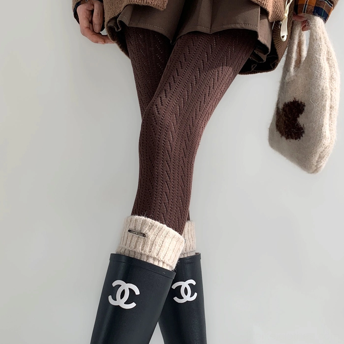Dark brown Jirai Kei hollow stripe tights rear angle showing twisted hollow pattern with fuzzy handbag coordinate