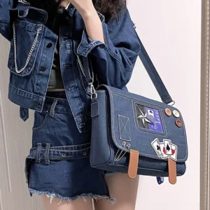 Dark blue denim Jirai Kei itabag crossbody handbag worn by model in denim coordinate set, front view displaying decorative patches and brown leather straps with large capacity design