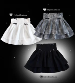 Three color variations of the double-layered jirai kei skirt displayed flat on black background, showing white, gray lace, and black options with bow details and ruffled hem texture