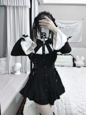Rear three-quarter view of black and white Jirai Kei dress with bell sleeves featuring tiny bows, side lace-up corset details, ruffled skirt hem, and twin-tailed hairstyle styling complete Jirai aesthetic