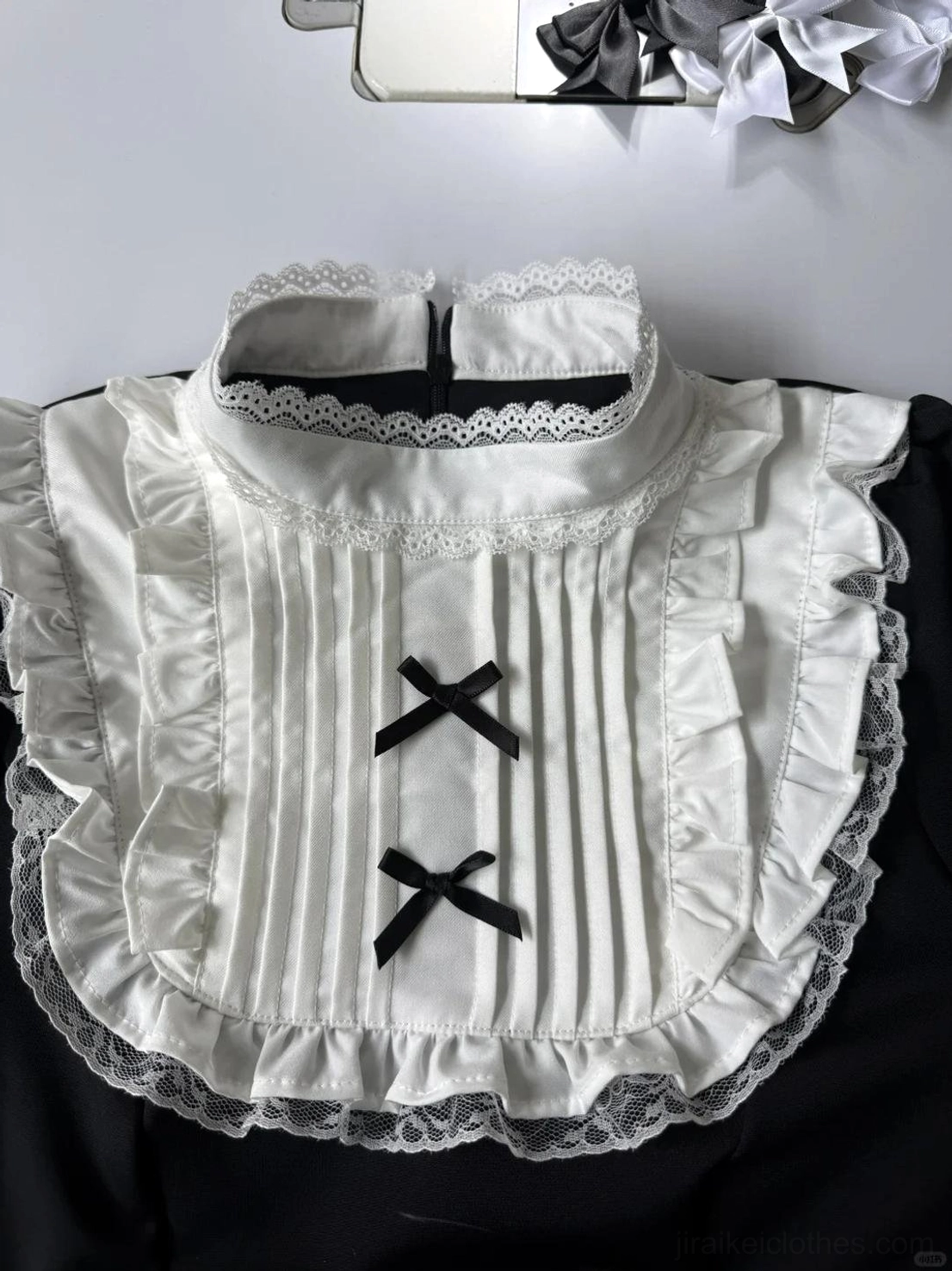 Jirai Kei dress collar stand detail white lace trim black cross bows pleated ruffled fabric neckline close-up flat lay