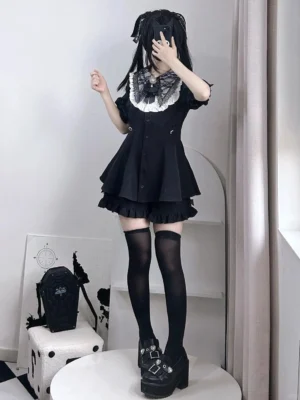 Black Jirai Kei dress set with white lace puritan collar and ruffled hem, worn with thigh-high socks and platform boots in full-body front standing studio view