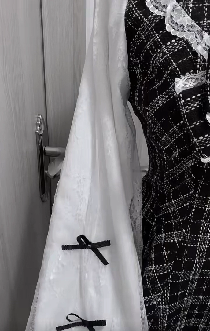 Jirai Kei dress accessories and construction detail: spare white lace sleeves with tiny bows, black and white plaid tweed vest fabric, showcasing material quality and craftsmanship