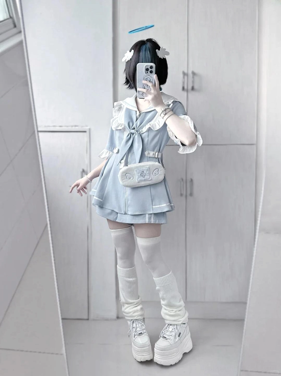 Close-up detail shot of white pleated lace trim and ruffled cuff elements on pastel blue Jirai Kei sailor dress showcasing craftsmanship and fabric quality