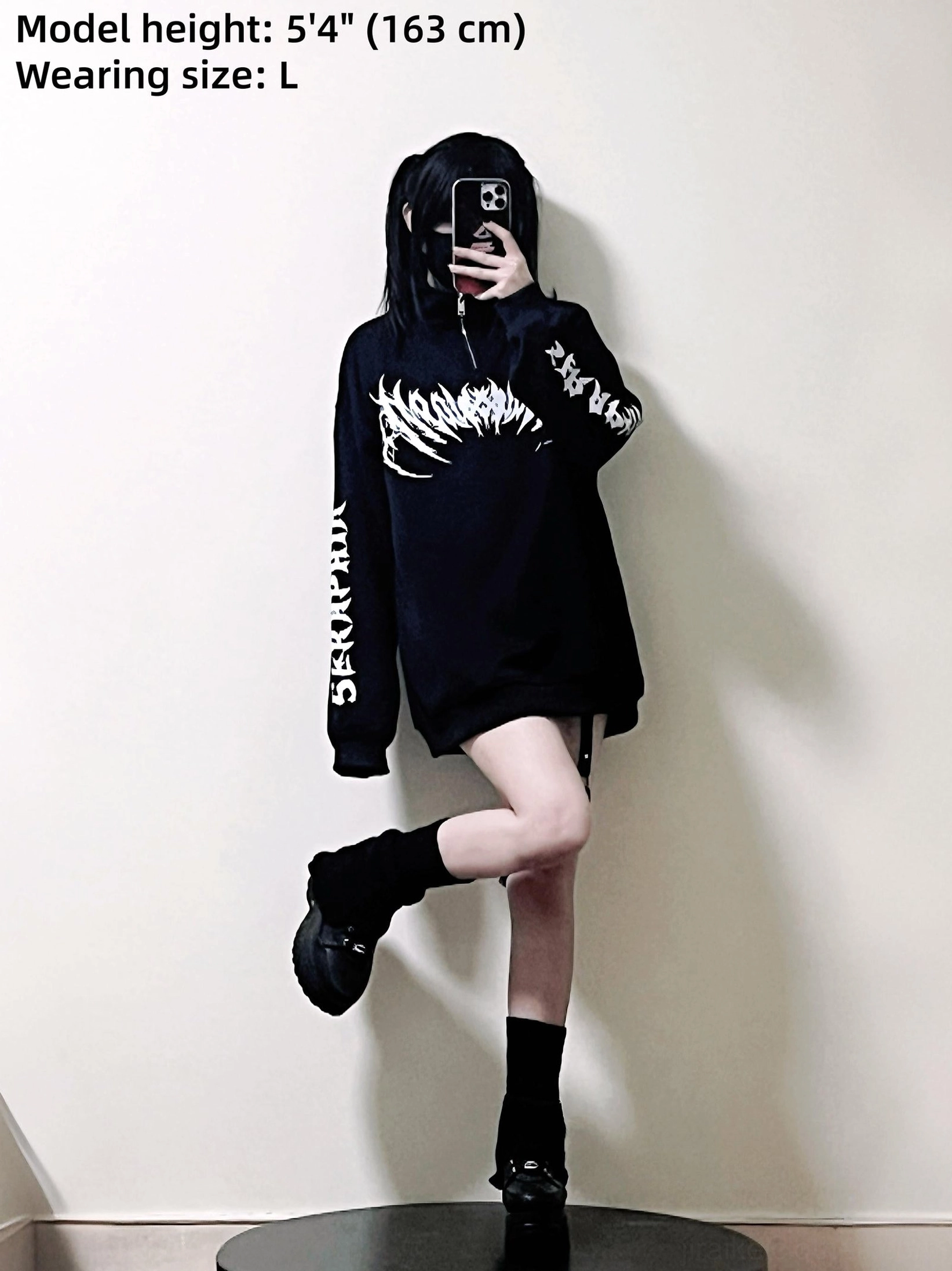 Female model wearing black gothic sweatshirt in oversized fit size L, selfie mirror perspective showing authentic styling and proportion on 163cm frame