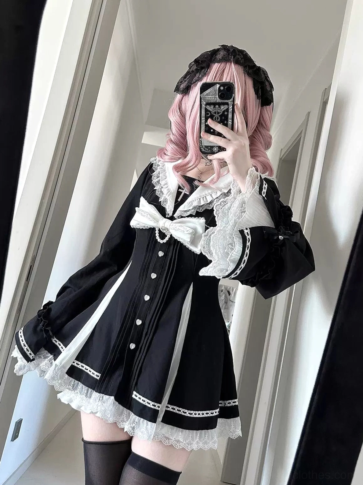 Black and white Jirai Kei gothic lolita dress styled on pink-haired female model wearing thigh-high stockings, mirror selfie showing front button placket and dark romantic aesthetic