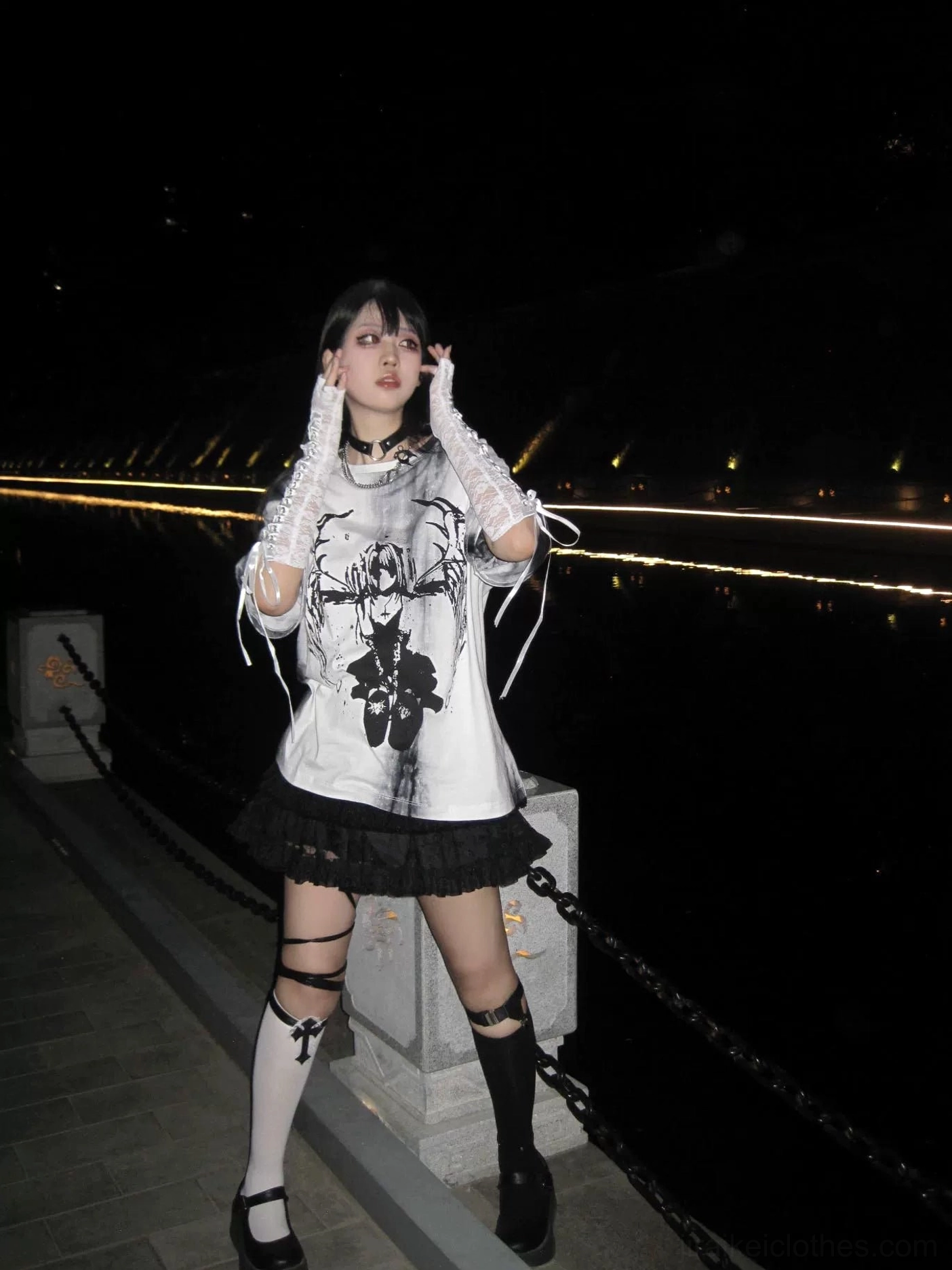 Black-haired model in celestial gothic tie-dye jirai kei t-shirt with lace-up side details, paired with ruffled skirt and strap thigh-highs