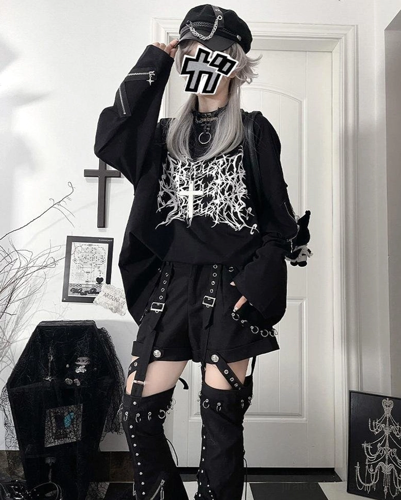 Lifestyle fashion photography of jirai kei oversized long-sleeve gothic tee styled in underground alternative aesthetic setting with complementary dark fashion pieces