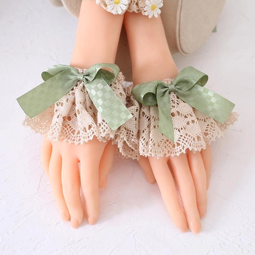 Green Jirai Kei lace headband with layered decorative bows, beige lace trim, and pearl bead chains featuring tiny gold charm pendants on blonde wig front view—romantic alternative fashion headpiece