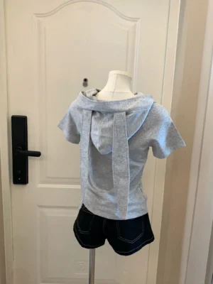 Heather grey jirai-kei bunny ear hooded t-shirt back view mannequin display, showing elongated bunny ears hood design with printed shorts