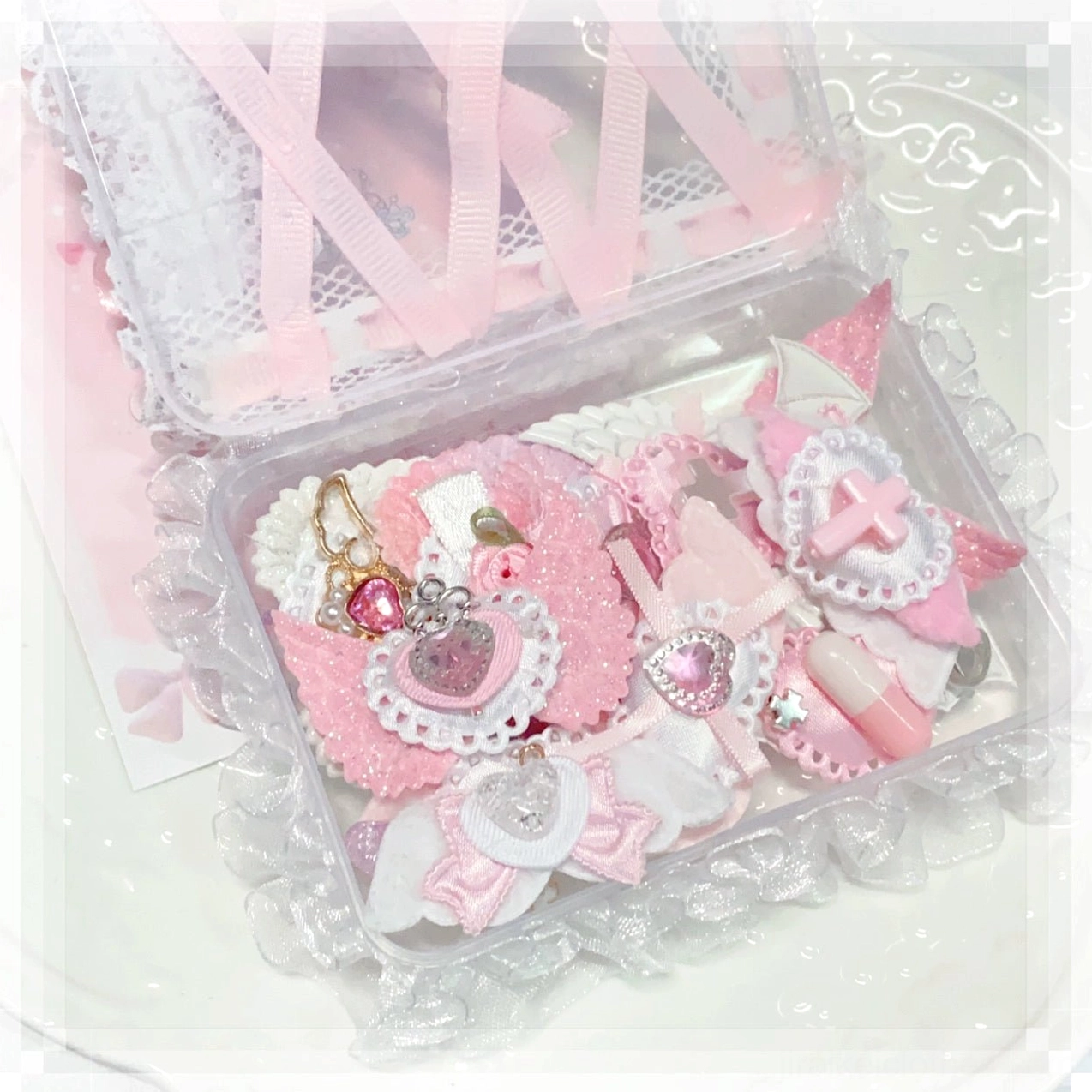 Boxed pink jirai kei hair accessory set in lace-trimmed clear storage box with pink white tones heart cross and rhinestone decorations