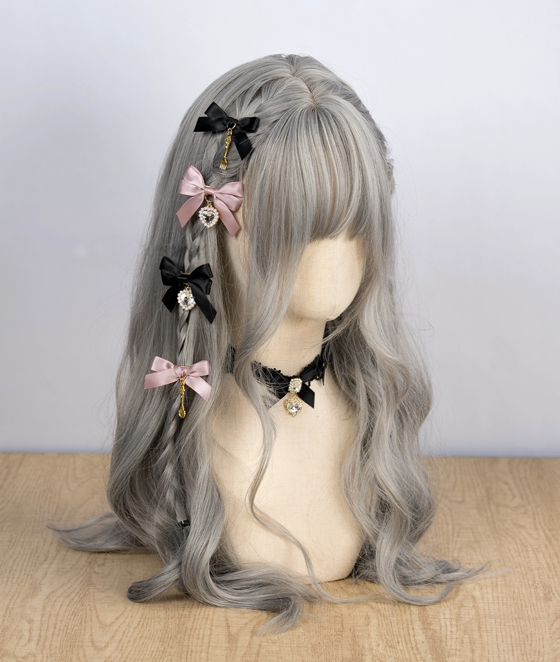 Jirai Kei bow hair clips featuring mixed black pink and brown satin bows with rhinestone and cutlery pendants on mannequin with gray wavy wig and lace choker