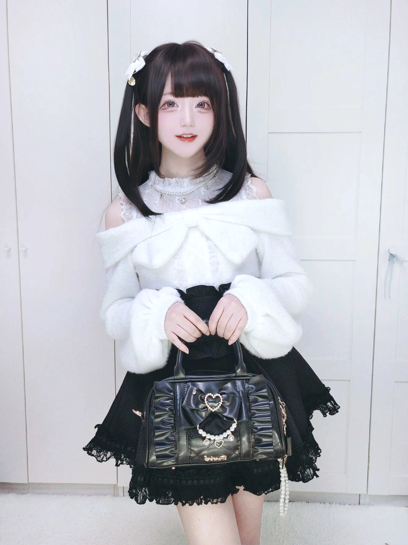 Fashion model carrying Jirai Kei handbag with pearl tassel decoration, sweet Lolita coordinate with twin ponytails, medium front shot