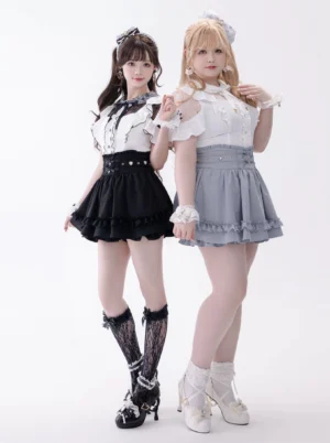 Two models wearing matching Jirai Kei high-waist ruffled skirts with rhinestone details in full-body studio shot showcasing sweet lolita aesthetic