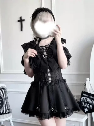 Black Jirai Kei high-waist skirt with lace ruffle trim and rhinestone heart accents, front three-quarter view on model wearing matching ruffled long-sleeve top