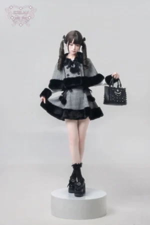 Complete Jirai Kei houndstooth outfit set displayed on stand, coordinated cape and high-waisted skirt with pom-pom details, paired with studded black handbag and platform ankle boots