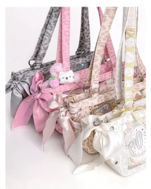 Flat lay collection of multiple colored Jirai Kei ita bags showing denim and leopard print styles with decorative satin bows and lace trims