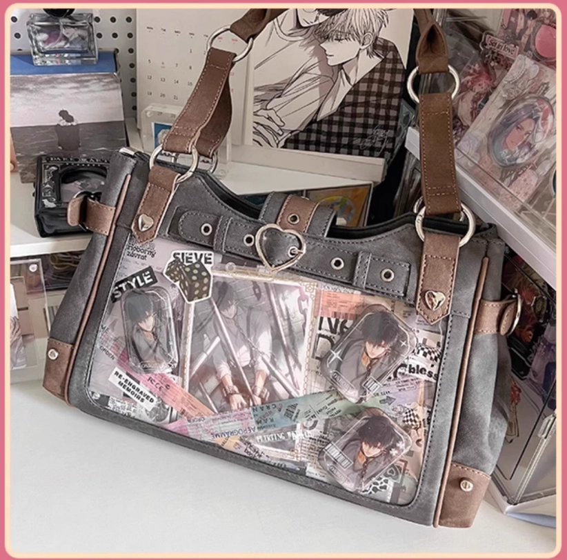 Front flat view of punk aesthetic Jirai Kei ita bag overflowing with anime stickers pins and collectibles in transparent window, full-frontal display of decorative personalization