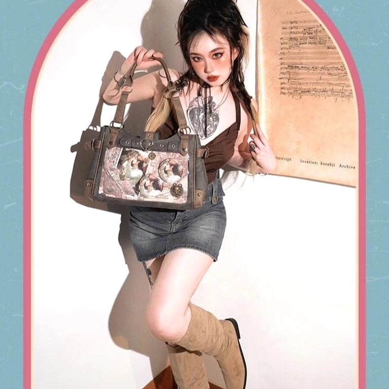 Female model showcasing Jirai Kei ita shoulder bag with round anime pins and decorative elements visible through transparent window, Y2K punk style aesthetic with arched indoor backdrop