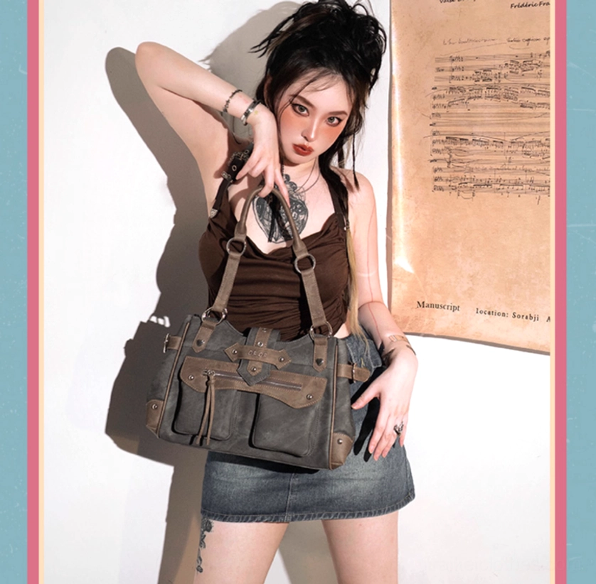 Front medium shot of model wearing sky blue Jirai Kei ita crossbody bag with distressed leather finish and multiple front decorative straps on sheet music indoor backdrop