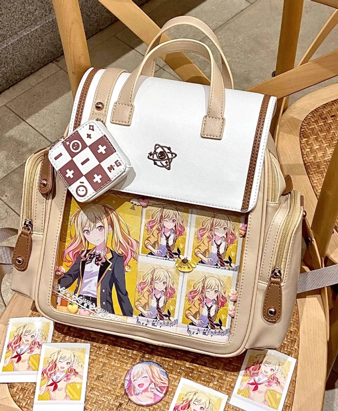 Jirai Kei itabag backpack rear three-quarter side view showing back embroidery and shoulder strap with anime cards and collectible badges