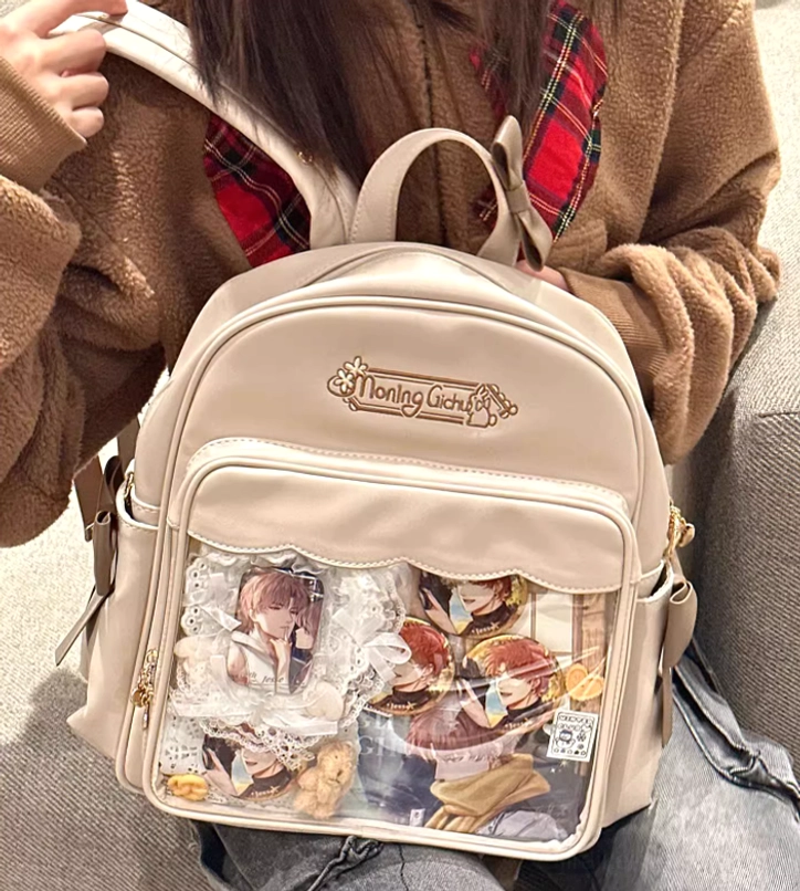 Beige itabag close-up front view multiple anime character display pockets on sofa lounge scene