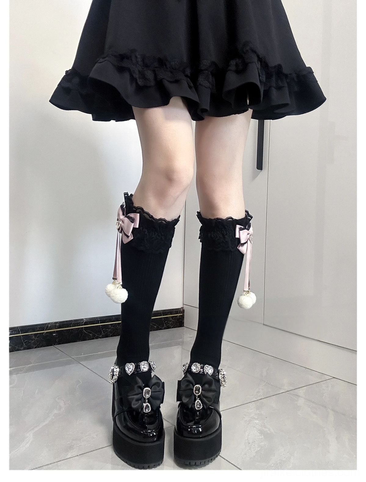 Matching Jirai Kei knee-high socks direct front full leg view solid black knee socks lace cuffs pink bows with hanging white pom-pom pendants platform loafer styling