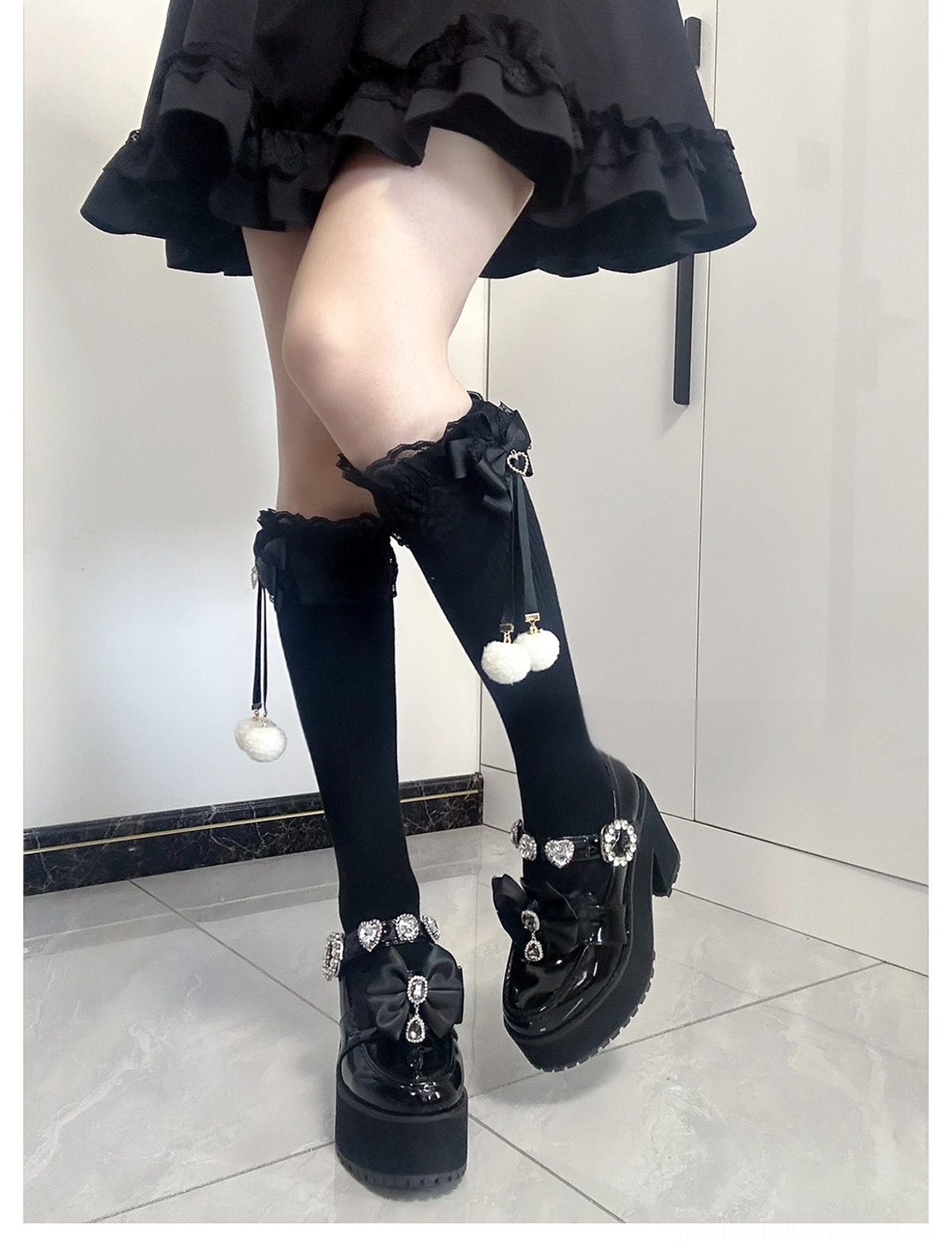 Jirai Kei knee-high socks white-pink colorway front full leg view showing delicate white and pink combination with lace cuffs and pom-pom accents on model wearing platform shoes