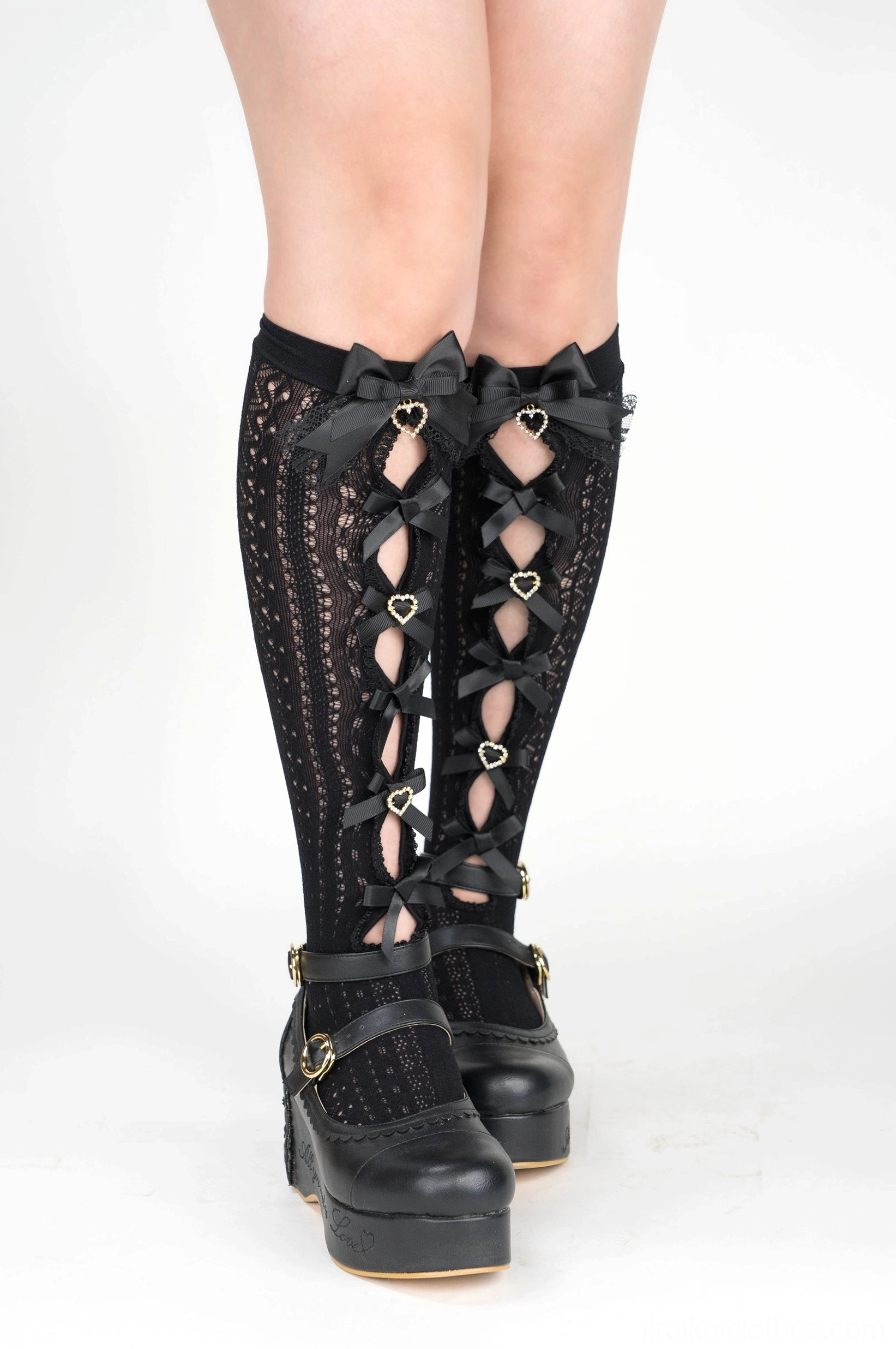 Black mid-calf Jirai Kei socks front full leg view featuring black ribbon bows heart-shaped rhinestone decorations with platform shoes