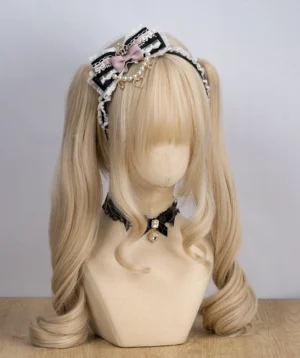 Jirai Kei black and white lace headband with pink accent bow, crystal rhinestone pendant and faux pearl chain detail on blonde mannequin