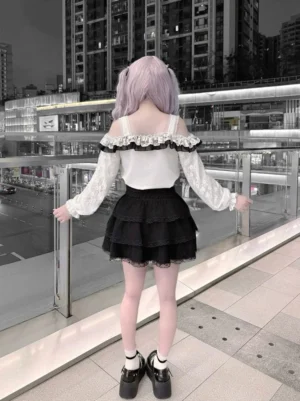 Black and white Jirai Kei set back view showing ruffled layered lace mini skirt and off-shoulder design outdoor night setting