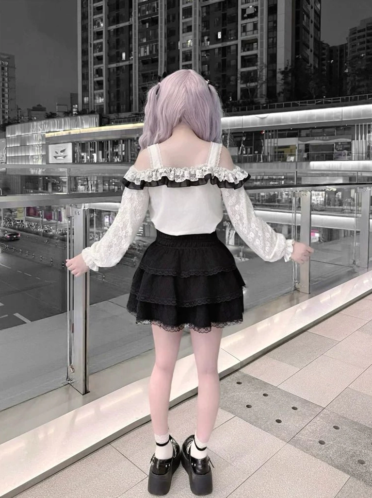 Black and white Jirai Kei set back view showing ruffled layered lace mini skirt and off-shoulder design outdoor night setting
