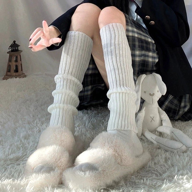 Bright white thick stacked rib knit jirai kei leg warmer over-the-knee length low front angle sitting on fluffy rug with plush toys
