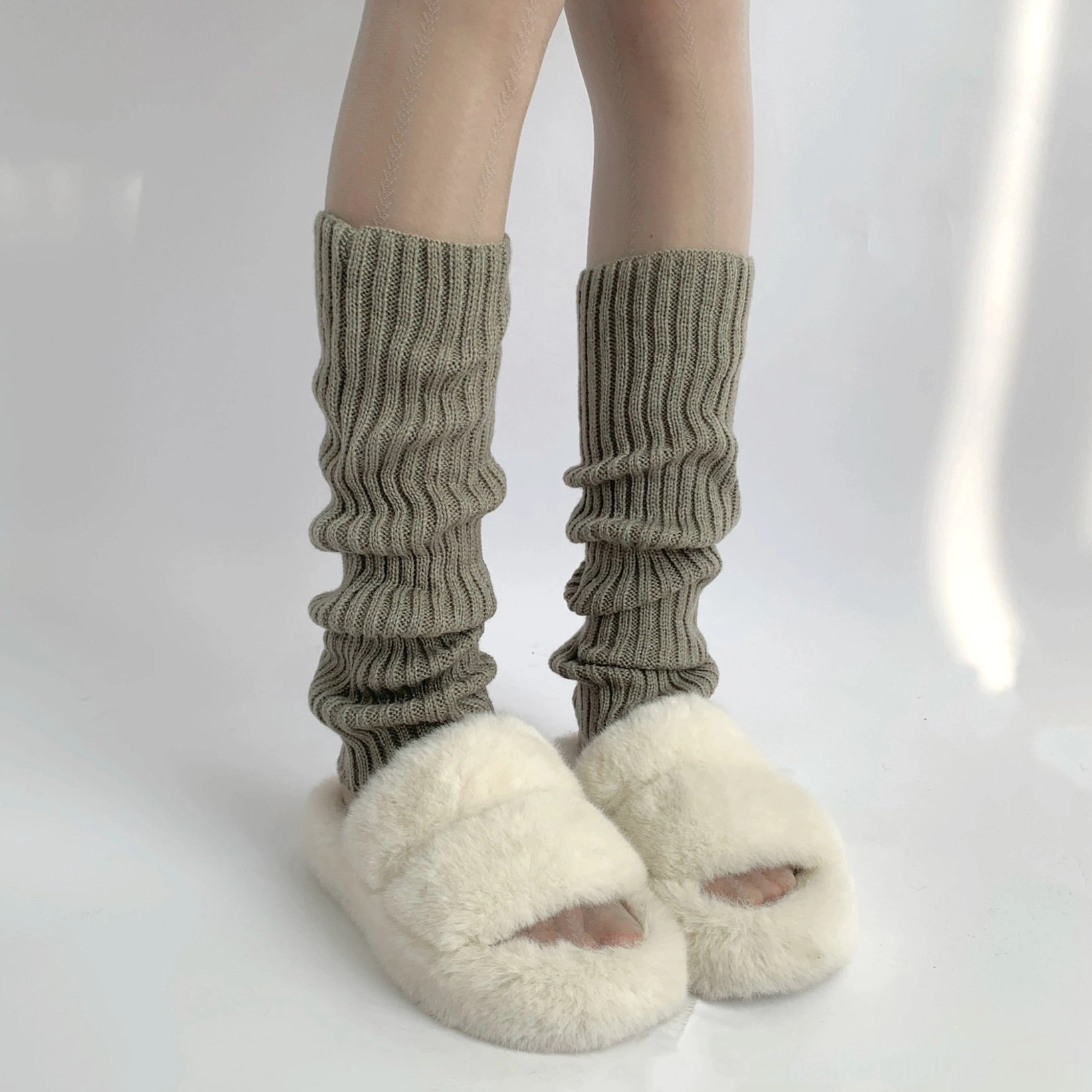 Heather grey loose stacked rib texture jirai kei leg warmer mid-calf close-up front view with fuzzy slide sandals indoor plain background