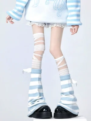 Three-quarter front view of sheer bandage wrapping thigh-highs paired with coordinating striped leg warmers and decorative wing charms Jirai Kei aesthetic styling