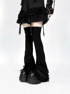 Black jirai kei over-the-knee leg warmers with white lace ruffled cuffs, low front view showcasing flared silhouette and anti-slip band