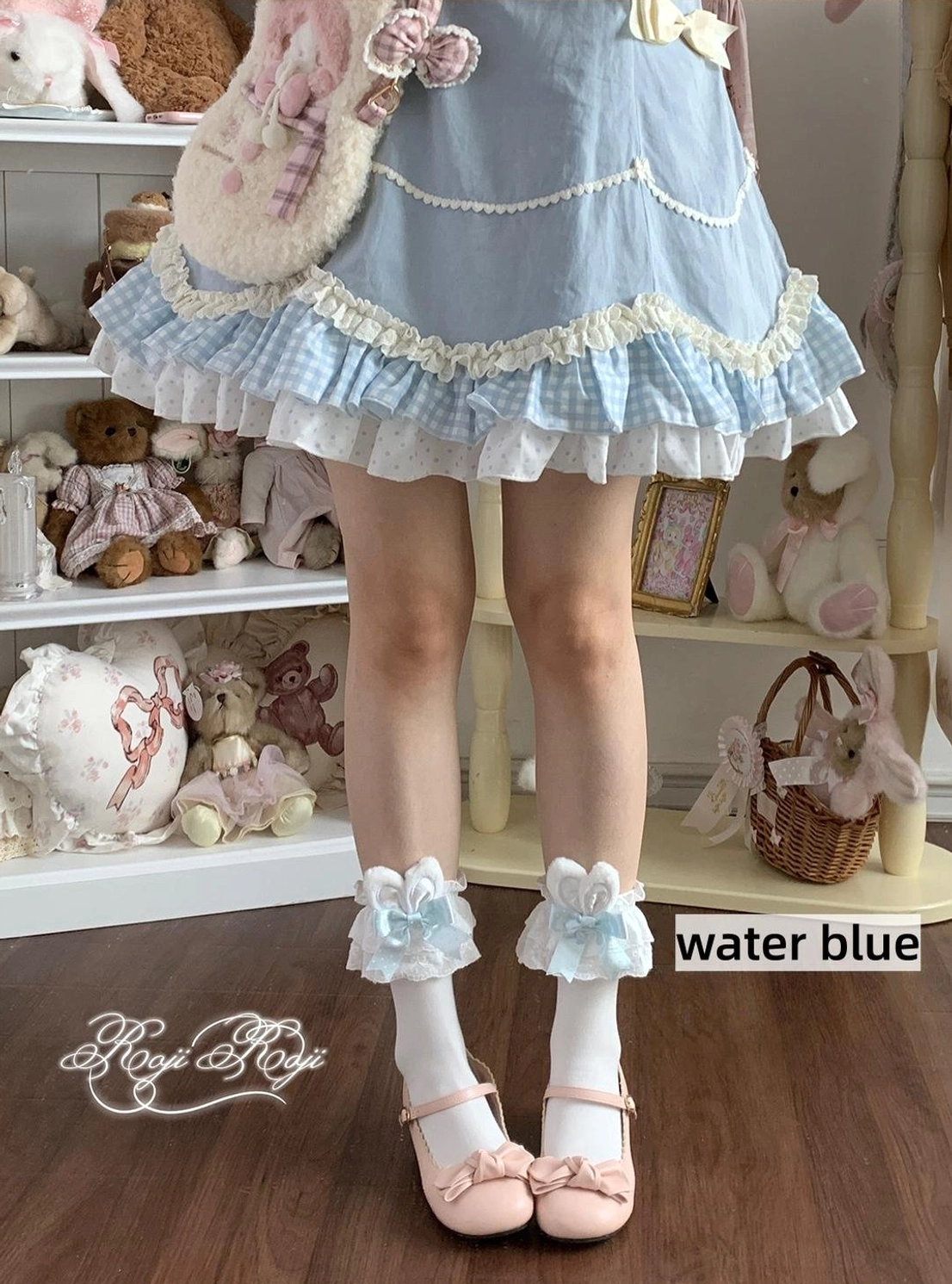 Jirai Kei light pink ruffled bunny ear socks with white base worn with light pink flat shoes and pink frilled Lolita skirt in specialty shop setting