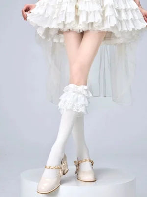 Jirai Kei style black and white lolita calf socks with layered lace ruffles and bow details paired with beige mary jane shoes and white ruffled skirt