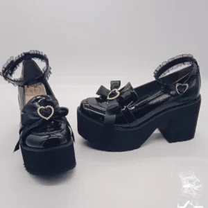 Black patent Lolita platform shoes side angled view showing thick block heel heart buckle bow decoration glossy finish