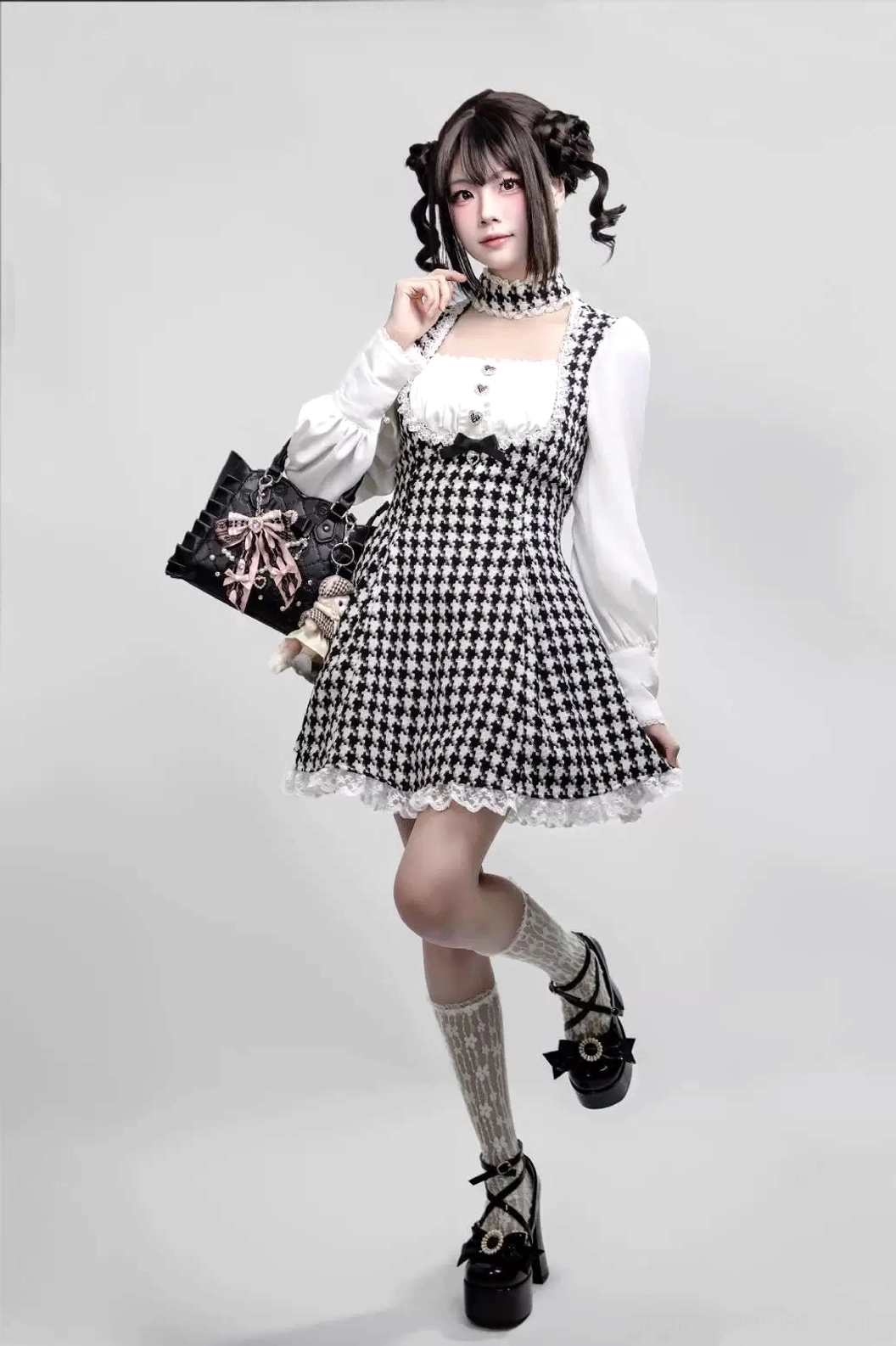 Close-up detail of houndstooth Jirai Kei maid dress fabric pattern, integrated non-detachable choker neck design, and rhinestone embellishment on heart buttons