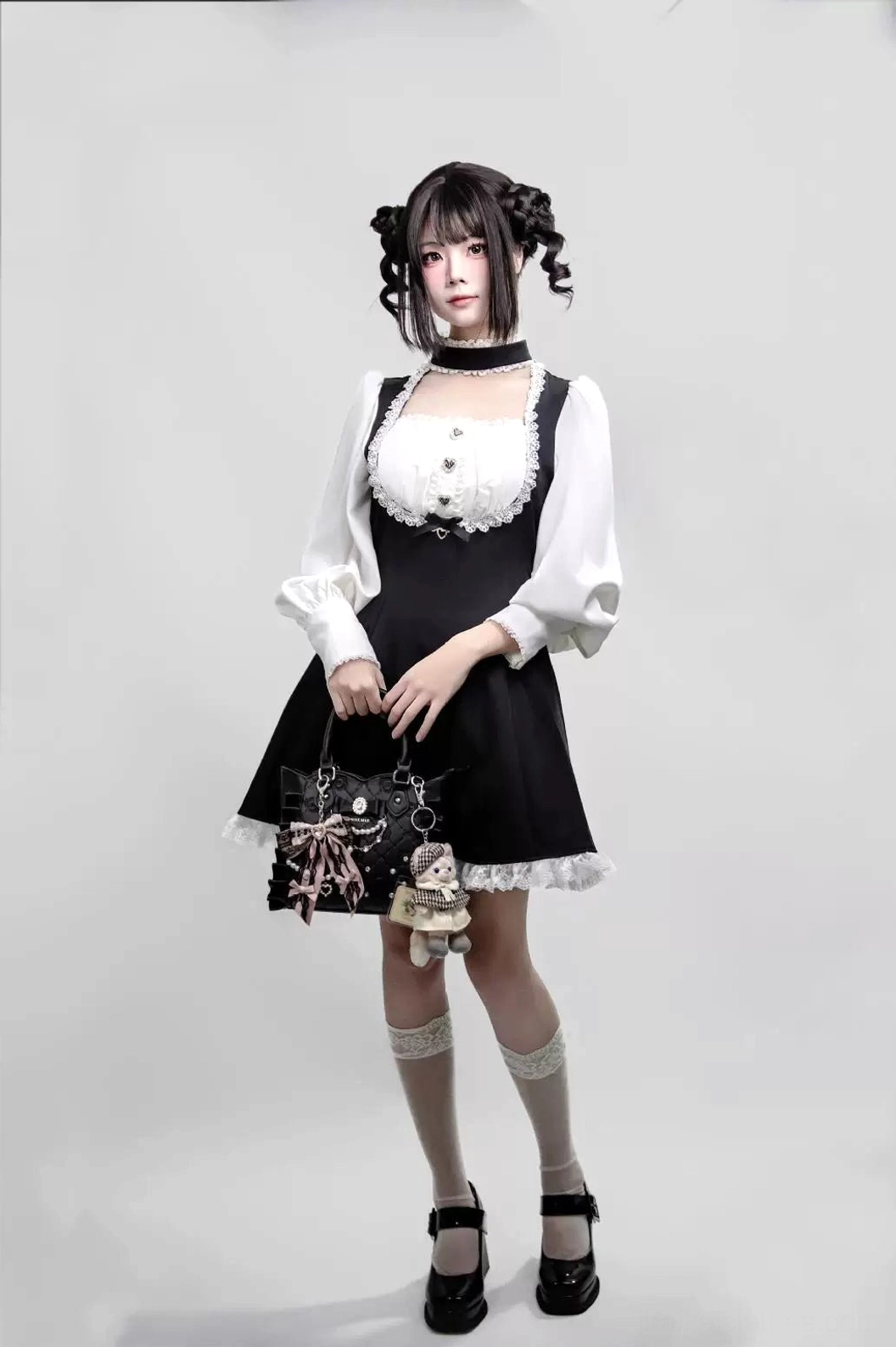 Detailed view of heart-shaped button placements, rhinestone bow accents on bust area, and lace-trimmed chest design of Jirai Kei maid dress with integrated choker
