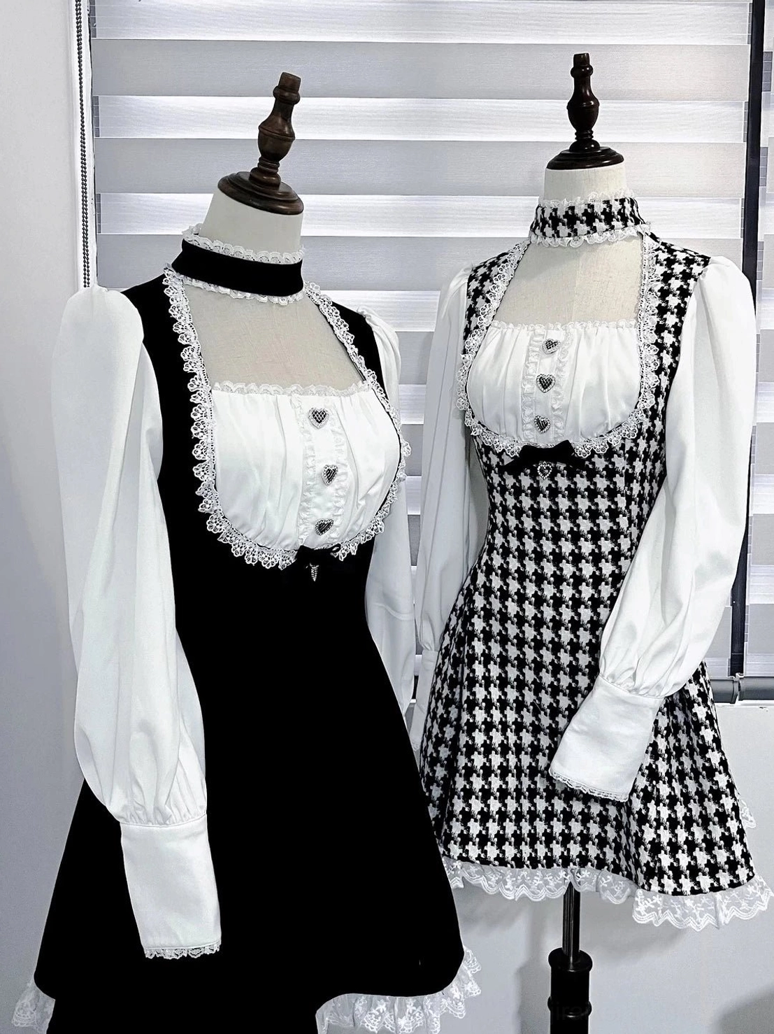 Eye-level front view of mannequin-displayed Jirai Kei maid dresses showing lace-trimmed bust, cuffs, attached non-detachable chokers, and two distinct fabric pattern options