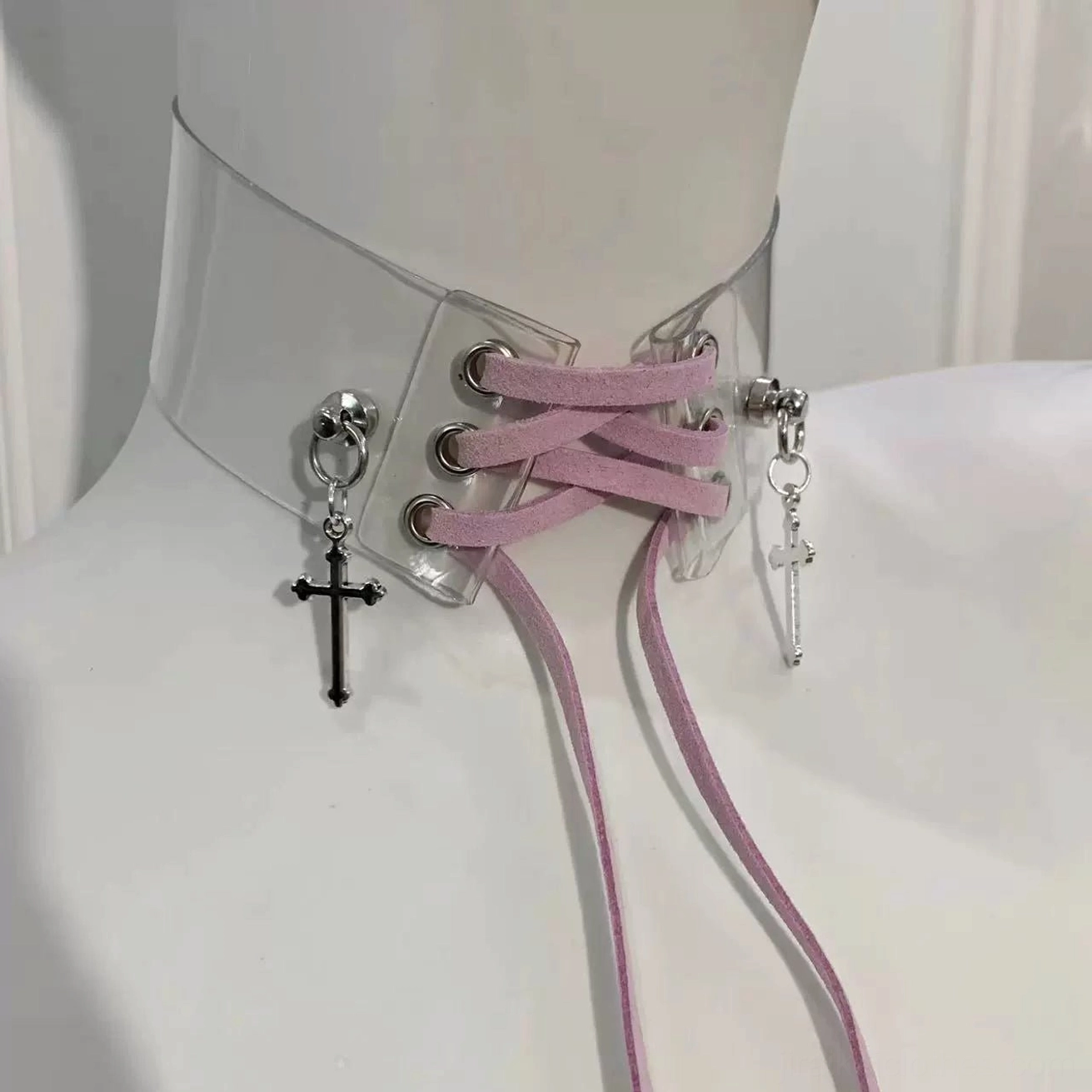 Mauve pink Jirai Kei transparent choker necklace with adjustable lace straps and mixed black and silver cross pendants, angled perspective