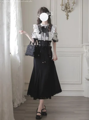 Jirai Kei two-piece outfit front three-quarter view featuring off-shoulder white lace blouse with floral cut-outs and black mermaid skirt with leather accents and crisscross waist strap worn by model with handbag