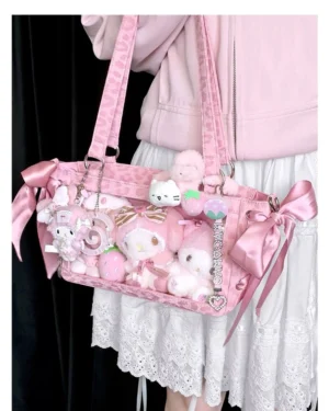 Pink Jirai Kei mini ita bag worn on shoulder by model showcasing clear window display with plush toys and satin ribbon bows