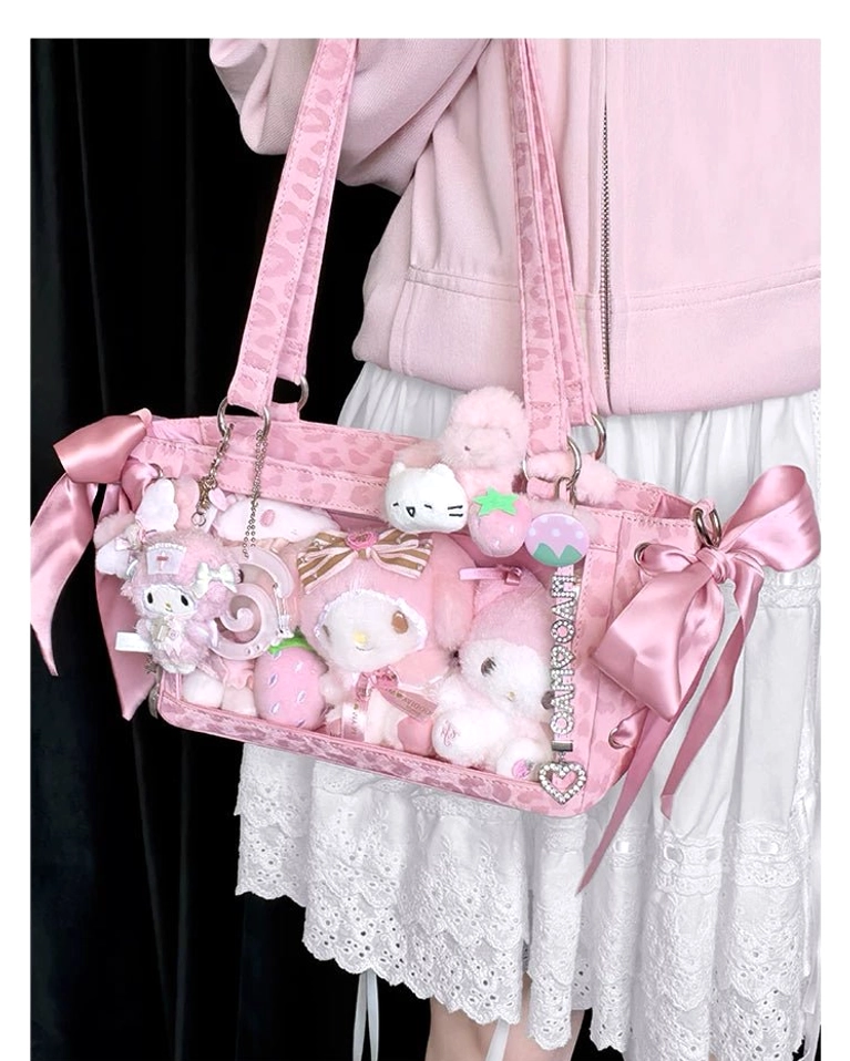 Pink Jirai Kei mini ita bag worn on shoulder by model showcasing clear window display with plush toys and satin ribbon bows