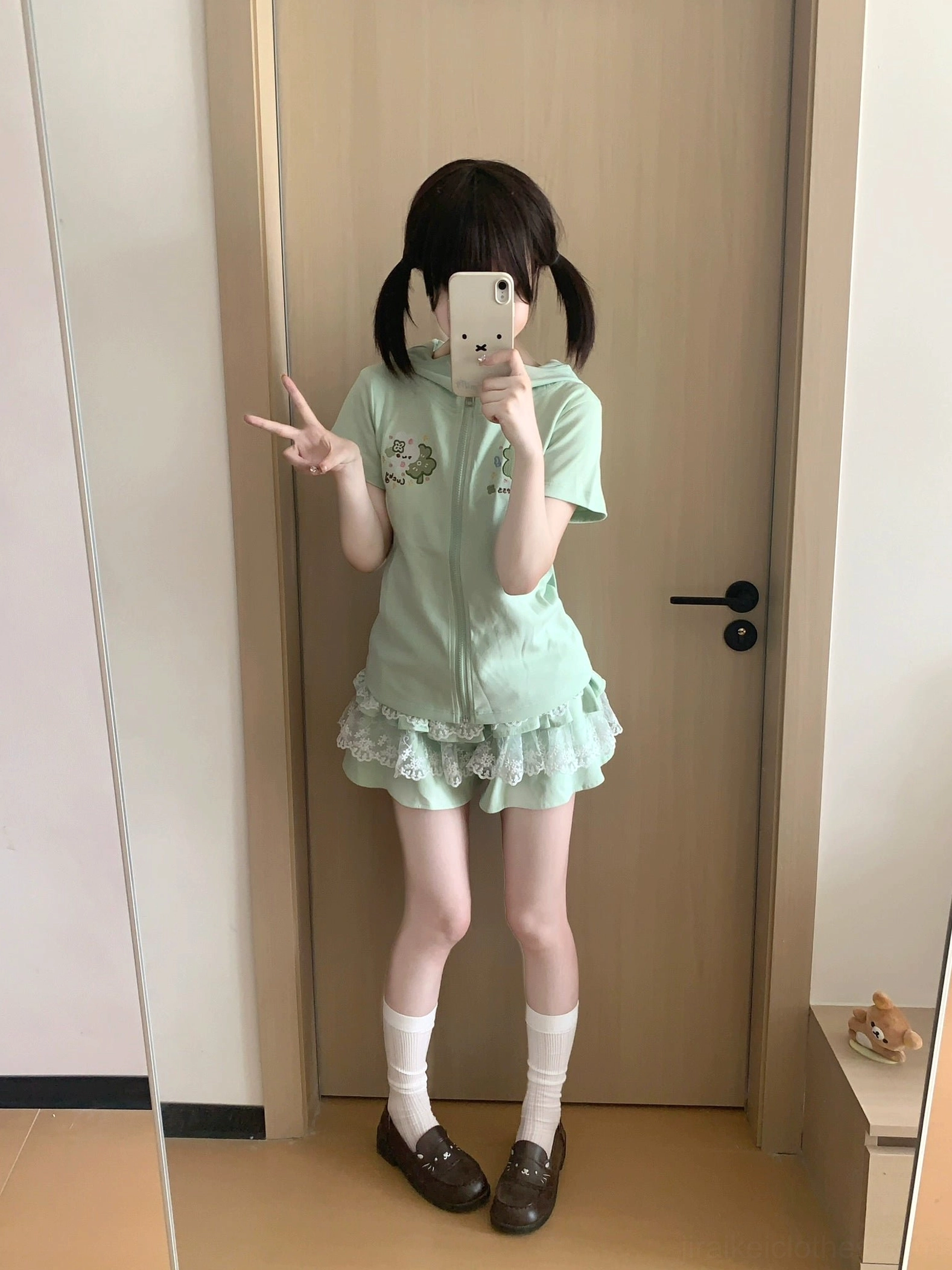 Jirai Kei mint green outfit set on model with peace sign pose, short-sleeve zip hoodie with bunny ear hood and ruffle lace skirt, front mirror selfie kawaii aesthetic