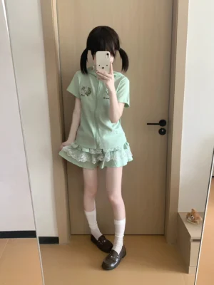 Mint green Jirai Kei bunny ear zip hoodie and tiered lace ruffle skirt set worn by model with twin-tail hairstyle, front mirror selfie perspective showing complete outfit with white socks and brown loafers