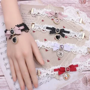Assorted Jirai Kei bow choker and wrist accessory collection with heart rhinestones flat lay on sheet music background, multiple color options display